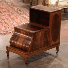 an old fashioned wooden box sitting on top of a floor next to a rug and chair