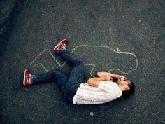 a man laying on the ground with his feet up in the air next to a chalk drawing that says, this could be us