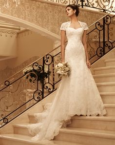 a woman in a wedding dress standing on some stairs