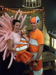 a man and woman are dressed up as characters from the cartoon nemo with their child