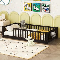 a baby crib in a nursery with pictures on the wall