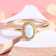 "Here is Oval Opal Gold Halo Wedding Ring for Bride, You can use it as a 14K Custom Birthstone Multicolor Art Deco Band. Our 18K Personal Gemstone Jewelry is use as Mystical Gifted Hers Ring. This oval gemston ring looks like dainty mystical ring. Personal jewelry lab opal ring band will be perfect gift for mothers birthday. Dainty halo wedding band can be customized with your Mom's Birthstone Ring. We can turns it into a art deco engage ring. Our 10K comfortable fitting ring is great multicolor 14k Gold White Opal Birthstone Ring, White Opal Birthstone Ring In 14k Gold, Gold Opal Ring With Halo Design, White Hallmarked Birthstone Wedding Ring, Gold Opal Birthstone Wedding Ring, White Opal Ring Stamped 14k For Gift, White Opal Ring Stamped 14k As Gift, Gold Opal Wedding Ring Stamped 14k, Gold Opal Ring With Halo Design - Gift