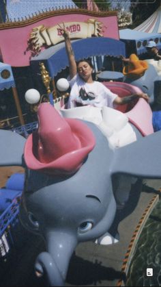 a man riding on top of an elephant shaped ride at a carnival or amusement park