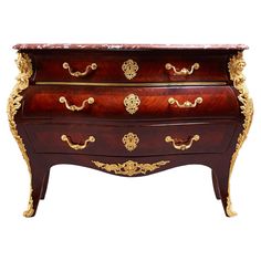 an ornately decorated chest of drawers with gold trimmings on the top and bottom