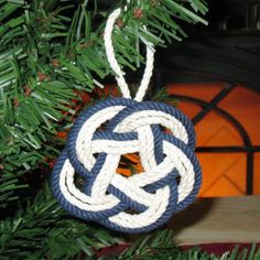 a blue and white ornament hanging from a christmas tree