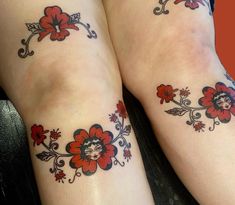 two women with tattoos on their legs and one has a flower tattoo on her leg