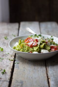 a white bowl filled with salad on top of a wooden table