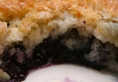 a close up of a piece of cake with blueberries and cream in it's center