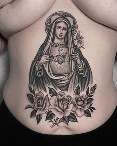 a woman's stomach with an image of the virgin mary and roses on it