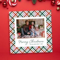 a christmas card with an image of two people and a dog sitting on the floor