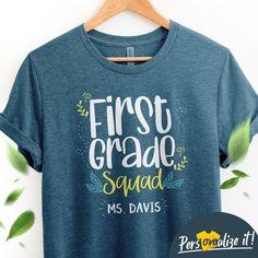 a t - shirt with the words first grade squad on it and leaves around it