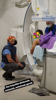 a man sitting on top of a toilet next to a woman in a purple dress