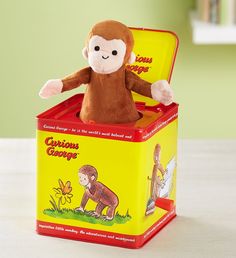 a stuffed monkey sitting in a yellow box