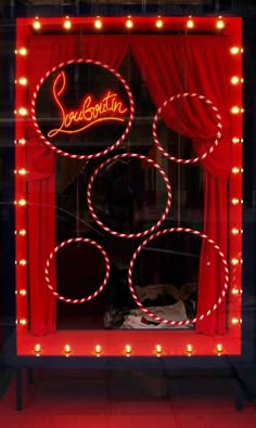 a lighted display window with red curtains and lights