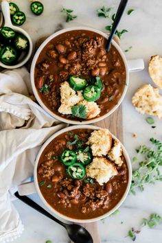 two bowls filled with chili and cauliflower on top of a marble countertop