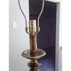 an old fashioned lamp is sitting on a stand in a room with tile flooring