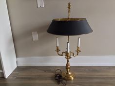 a table lamp sitting on top of a hard wood floor next to a light switch