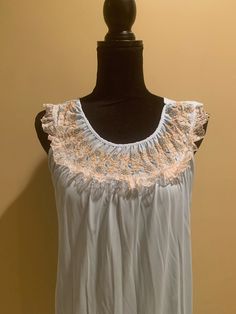 Lovely lightweight nylon nightgown in light blue. A good choice for the warmer months, as it is sleeveless. Contrasting lace trim on the neckline, along with blue and gold embroidery. In good condition. There is very slight discoloration in the underarm area, but not very noticeable. No rips. Made in the USA size medium. The bust measures 18 inches from armpit to armpit laying flat, 35 inches from shoulder to hem. Please examine the pics, feel free to ask questions. Sleeveless Night Dress With Contrast Lace, Sleeveless Dress With Contrast Lace For Night, Sleeveless Summer Sleepwear With Contrast Lace, Summer Sleepwear With Contrast Lace, Sleeveless Contrast Lace Night Sleepwear, Sleeveless Lace Patchwork Sleepwear, Sleeveless Sleepwear With Contrast Lace For Night, Sleeveless Coquette Bedtime Dress, Summer Sleeveless Nightgown With Lace Trim