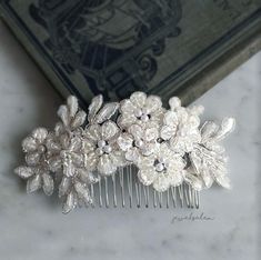 a close up of a hair comb with flowers on it and a book in the background