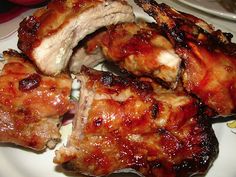 several pieces of meat sitting on top of a white plate