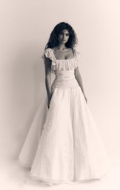 a woman in a white dress posing for the camera with her hands on her hips