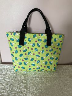 "This mushroom tote is just adorable.  The exterior fabric is covered in large mushrooms and pink flowers on a light lime background.  The interior is covered with mushrooms in black and white!  The bag measures 10.25\" wide by 9.25\" tall by 4 1/4\" deep.  It measures 13.25\" across the top.  The bag from the bottom to the top of the handles measures 14.25\".  It has a magnetic closure at the top of the bag. It has two interior pockets that measure 6 1/2\" wide by 5 1/2\" tall.  The divider pocket measures 11 \" wide by  6\" tall and is made in the lime green mushroom print fabric and is lined with the black and white mushroom fabric. It has a 8.75\" zipper. The handles have about a  5\" drop. The interior of this bag is interfaced with fusible fleece and a medium weight stabilizer which Black And White Mushroom, Lime Background, Mushroom Fabric, Green Mushroom, White Mushroom, Large Mushroom, Mesh Tote Bag, Mushroom Print, White Mushrooms