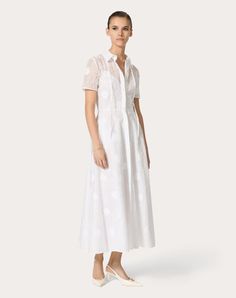 Daisy Organdis Midi Dress - Concealed front button fastening - Daisy Organdis (93% Cotton, 7% Polyester) - Muslin lining (100% Cotton) - Length: 130 cm / 51.1 in. from the shoulders in an Italian size 40 - Sleeve length: 45 cm / 17.7 in. from the centre back in an Italian size 45 - The model is 176 cm / 5'9" tall and wears an Italian size 40 - Made in Italy The look of the model is completed by a Valentino Garavani VLOGO MOON Bag and Valentino Garavani The Bold Edition Shoes. Luxury Spring Dresses With Button Closure, Spring Luxury Dresses With Button Closure, White Formal Dresses With Button Closure, White Workwear Dresses With Covered Buttons, Elegant Short Sleeve Dresses With Covered Buttons, Formal Feminine White Shirt Dress, Elegant Short Sleeve Shirt Dress With Covered Buttons, White Evening Dress With Button Closure, Spring White Dresses With Covered Buttons