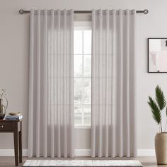 a living room with white curtains and a rug