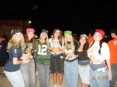 a group of young women standing next to each other in front of a building at night