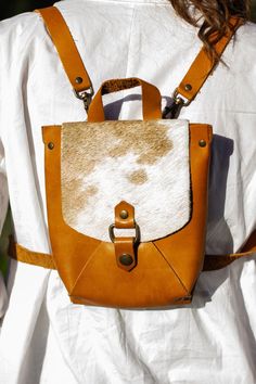 This leather backpack is in light brown colour. The straps are removable and adjustable. The height is 20cm, width 18cm. Brown On-the-go Bag With Adjustable Straps, Brown Leather Backpack With Adjustable Strap For On-the-go, Brown Backpack With Detachable Strap For School, Beige Leather Bag With Buckle Closure, Brown School Backpack With Adjustable Strap, Brown Leather Backpack With Detachable Strap For School, Brown Leather School Backpack With Detachable Strap, Brown Backpack With Detachable Strap For Daily Use, Brown Backpack With Adjustable Strap For Daily Use