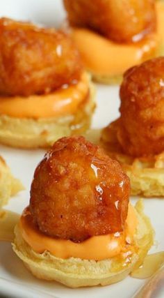 mini cheeseburgers with meatballs and sauce on them sitting on a white plate