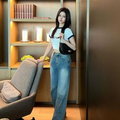 a woman standing next to a couch in a living room