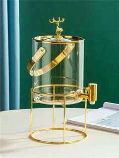 a glass container with a gold handle on a stand