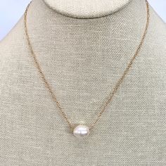 This elegant necklace showcases the timeless beauty of a single pearl delicately dangling from a dainty gold chain. The simplicity of the design highlights the natural allure of the pearl, creating a graceful and sophisticated piece. The necklace measures 16 inches in length, offering a classic and flattering fit around the neckline. Additionally, it can be adjusted to a shorter length of 15 inches, allowing you to wear it as a choker-style necklace for a more intimate and refined look. The sing Single Pearl Pendant, Dainty Gold Chain, Delicate Gold Necklace, Single Pearl, Choker Style Necklace, Classic Necklace, Pearl Collection, Elegant Necklace, Choker Style