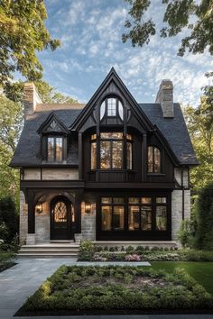 a large house with lots of windows on the front and side of it, surrounded by greenery