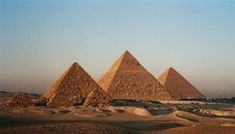 three pyramids in the desert with an arrow pointing to one side and two white arrows flying above them