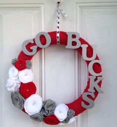 a red and white wreath with the word go back on it hanging from a door