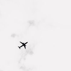 an airplane is flying through the cloudy sky