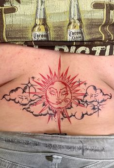 a woman's stomach with a sun and clouds tattoo on it