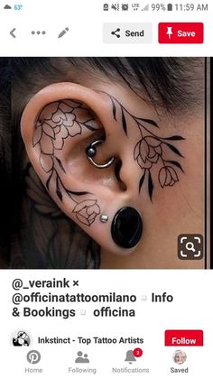 an ear tattoo with flowers and leaves on the inside of it, as well as a nose piercing