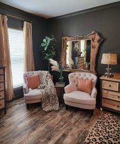 a living room with two chairs and a mirror on the wall next to a leopard print rug