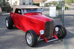 an antique red car parked on the street