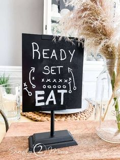 a sign that says ready set eat on it next to some flowers in a vase