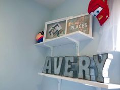 there is a shelf with pictures on it and the word avery spelled in metal letters