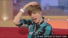 a young boy sitting on top of a red couch in front of a tv screen