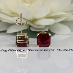 These earrings are radiant cut lab created red ruby studs , 14k yellow gold #6229 -Approximate total carat weight: 3.50ctw diamond equivalent -Stone Size: approx. 1.75ct each diamond equivalent -Gem Type: lab created ruby -Stone Shape: radiant cut 7x7mm each -Stone Clarity: AAA -Stone Color: red -Moh's Scale: 9 Hardness -Metal Type and Purity: 14k yellow gold -Setting: 4 prong basket setting -Stock Backing: screw backs -Country of Manufacturing: USA (Michigan) Custom Options: Moissanite Forever Gia Certified Ruby Earrings For Anniversary, Classic Radiant Cut Ruby Jewelry, Classic Radiant Cut Red Jewelry, Classic Red Radiant Cut Jewelry, Red 14k Gold Earrings For Anniversary, Gia Certified Red Emerald Cut Jewelry, Red Diamond Cut Earrings For Anniversary, Red Diamond Cut Anniversary Earrings, Red Faceted Earrings For Anniversary