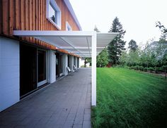 an outside patio with grass and trees in the background