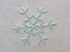 an embroidered snowflake on white fabric