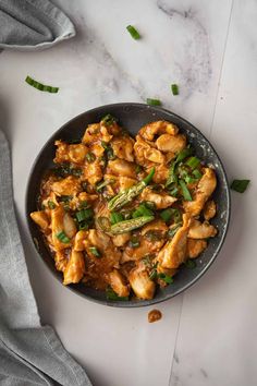 chicken and asparagus stir fry in a skillet on a marble countertop