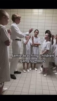 a group of people standing around each other in a room with words on the wall